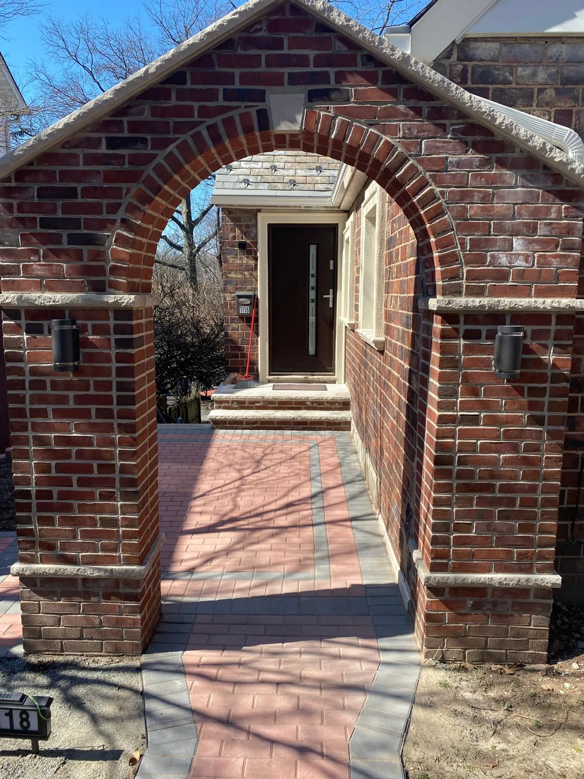 Red brick archway entrance with white door